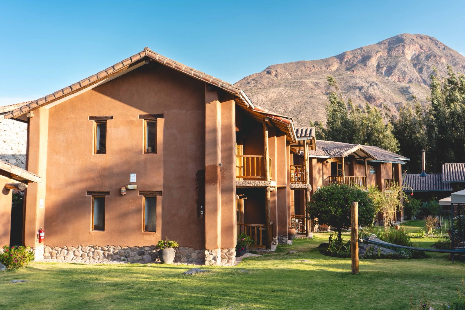 Fachada de adobe al atardecer con la montaña detrás