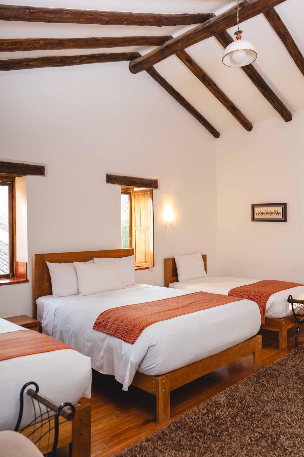 Habitación compartida con camas y textiles andinos