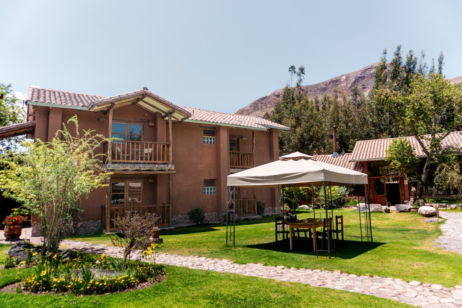 Casa de adobe con jardín frente a la montaña